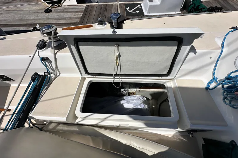 Slide: The Image of Open storage compartment on 1996 J Boats J/120 sailboat deck, with ropes and winches visible. - 31