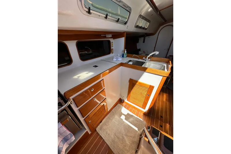 Slide: The Image of Interior of 1996 J Boats J/120 sailboat, featuring a wooden galley with sink and storage. - 39