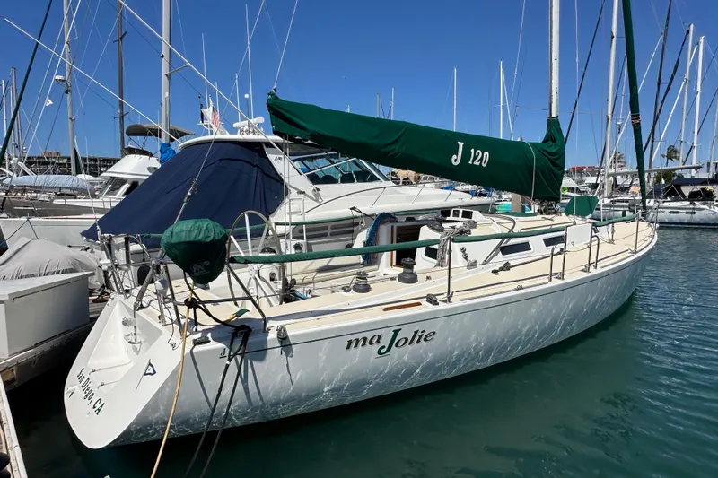 Slide: The Image of 1996 J Boats J/120 sailboat docked in marina, featuring green sail cover. - 4