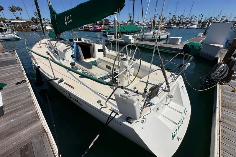 Slide: The Image of 1996 J Boats J/120 sailboat docked in a marina, featuring green sail covers. - 6