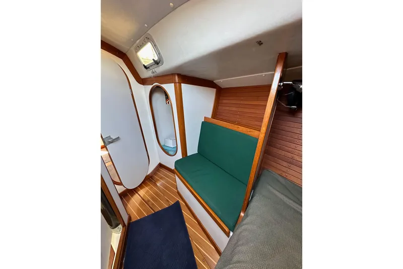Slide: The Image of Interior of 1996 J Boats J/120 sailboat with wooden paneling and green seating. - 80
