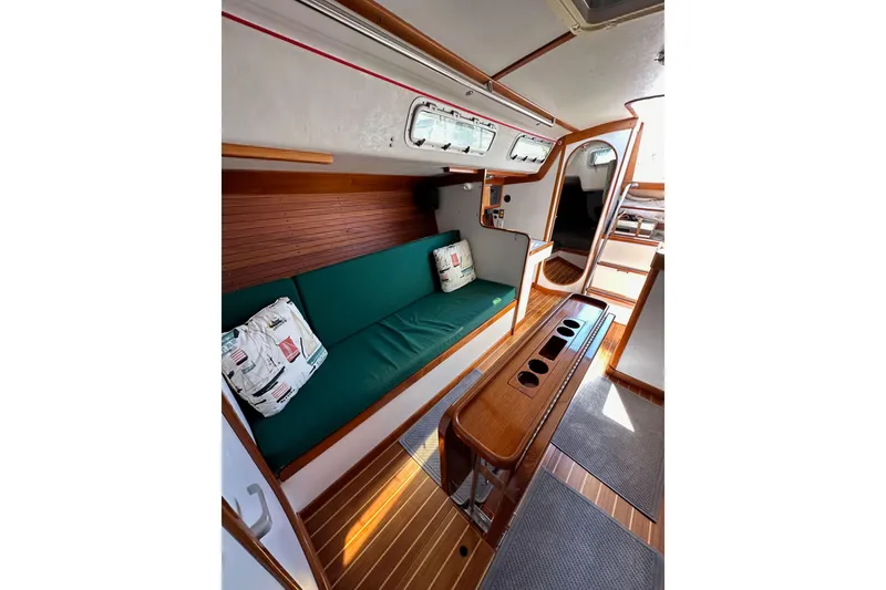 Slide: The Image of Interior of 1996 J Boats J/120 sailboat with green seating and wooden accents. - 83