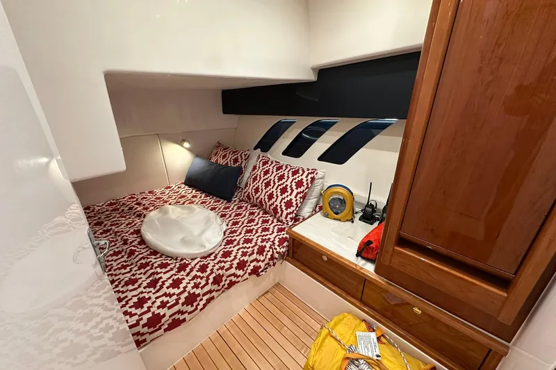 Slide: The Image of Cozy cabin interior of 2020 Intrepid 475 Sport Yacht with patterned bedding and wooden cabinetry. - 14