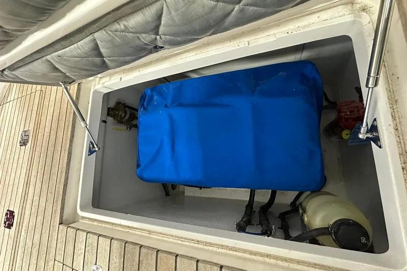 Slide: The Image of Storage compartment of a 2020 Intrepid 475 Sport Yacht with blue cover and mechanical components. - 27