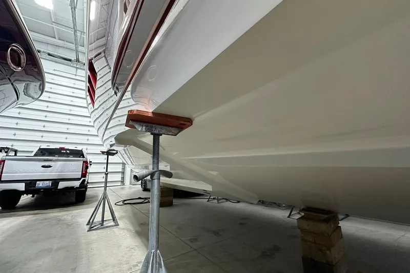 Slide: The Image of 2020 Intrepid 475 Sport Yacht in storage, supported by stands, next to a white truck. - 29