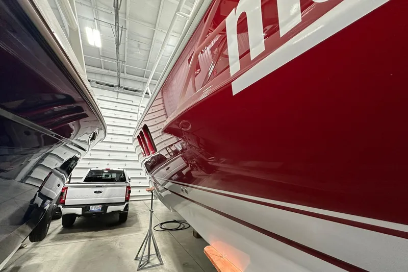 Slide: The Image of 2020 Intrepid 475 Sport Yacht in a garage, alongside a truck and another boat. - 30