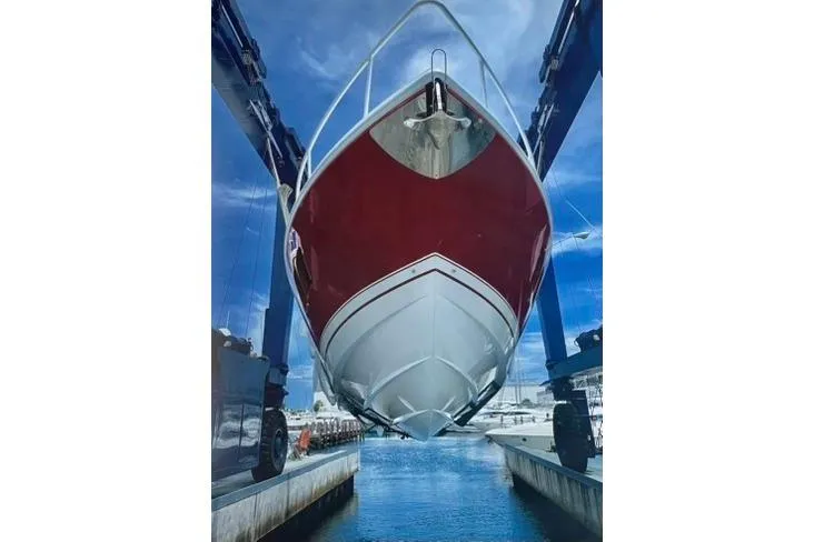 Slide: The Image of 2020 Intrepid 475 Sport Yacht in dry dock, showcasing sleek red and white hull design. - 39