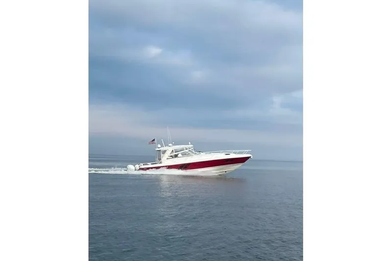Slide: The Image of 2020 Intrepid 475 Sport Yacht cruising on calm waters under a cloudy sky. - 42