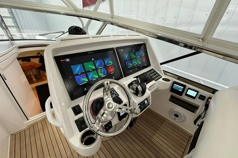 Slide: The Image of 2020 Intrepid 475 Sport Yacht helm with advanced navigation displays and controls. - 5