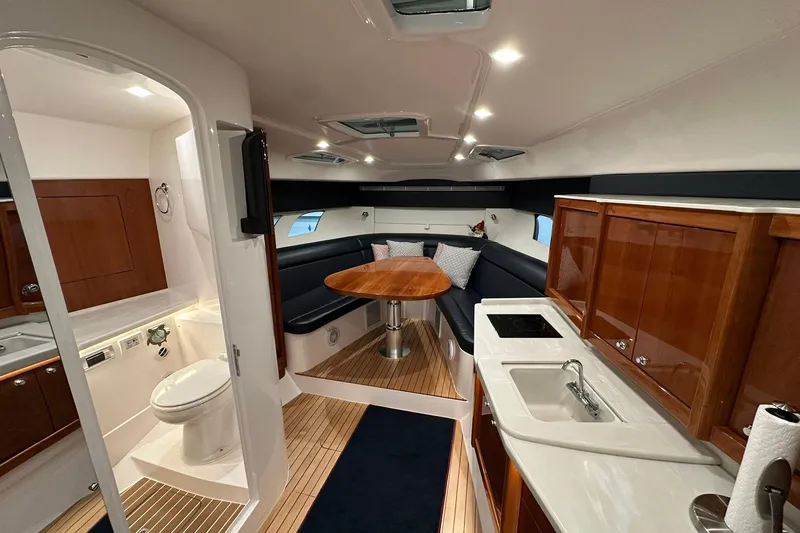 Slide: The Image of Interior of 2020 Intrepid 475 Sport Yacht with kitchen, seating, and bathroom. - 9