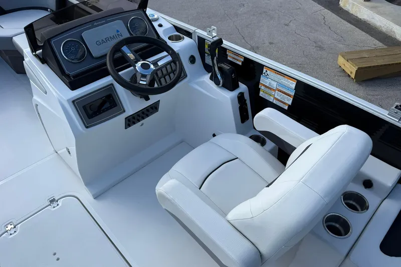 Slide: The Image of 2024 Hurricane FunDeck 2260 RE OB boat cockpit with Garmin navigation system and white captain's chair. - 13