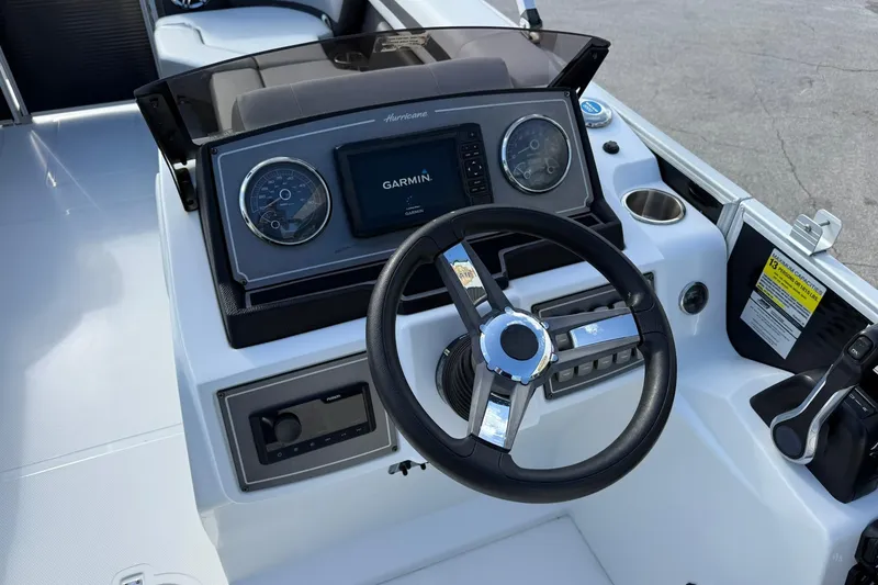 Slide: The Image of 2024 Hurricane FunDeck 2260 RE OB boat dashboard with Garmin display and steering wheel. - 14