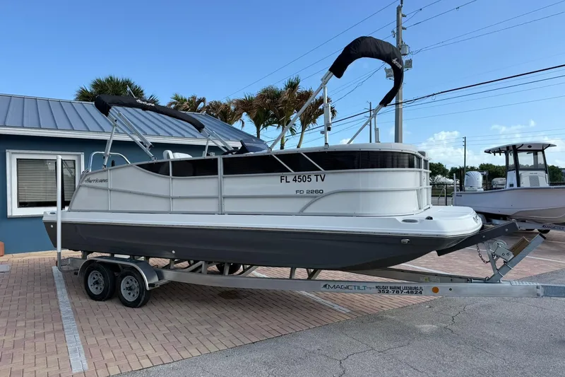 Slide: The Image of 2024 Hurricane FunDeck 2260 RE OB boat on trailer, parked outdoors. - 2
