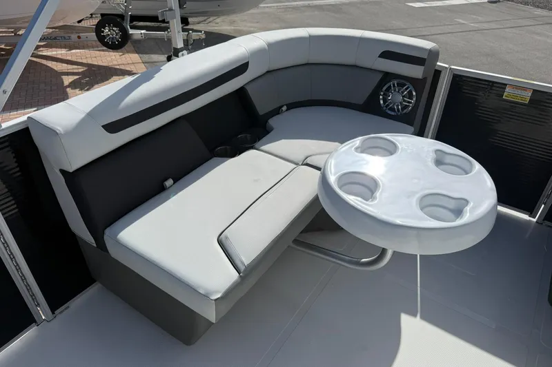Slide: The Image of 2024 Hurricane FunDeck 2260 RE OB boat interior with cushioned seating and cup holder table. - 25