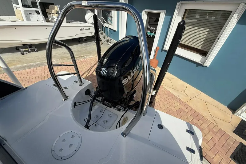 Slide: The Image of 2024 Hurricane FunDeck 2260 RE OB with Suzuki outboard motor, docked near blue building. - 6