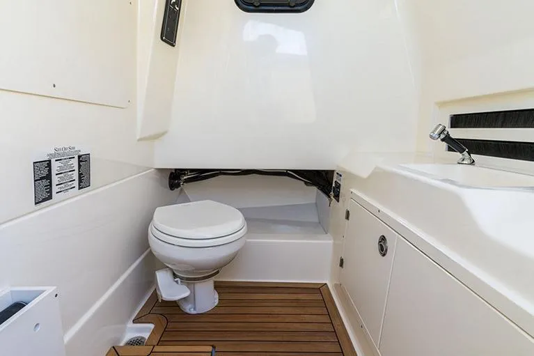 Slide: The Image of Manufacturer Provided Image: 2026 Boston Whaler 330 Outrage boat interior with toilet and sink. - 6
