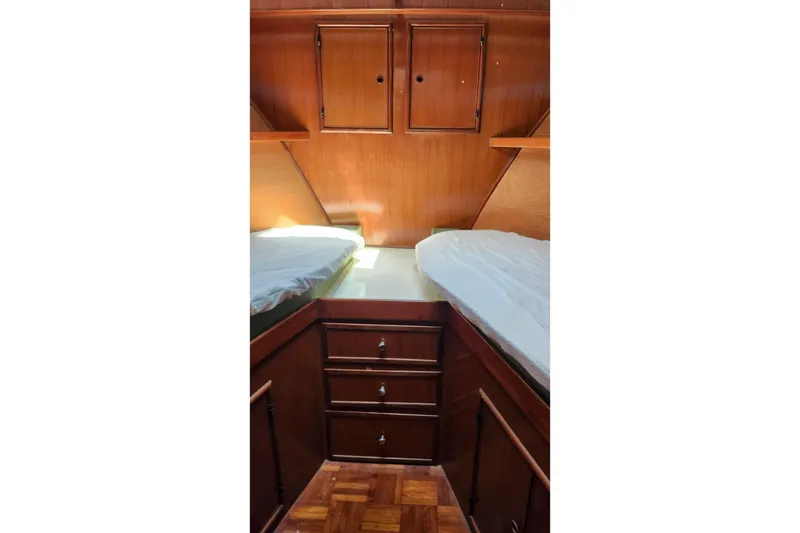 Slide: The Image of 1979 Marine Trader 50 Trawler cabin with twin beds and wooden cabinetry. - 19