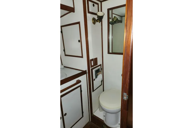 Slide: The Image of 1979 Marine Trader 50 Trawler bathroom with wood accents and compact design. - 23