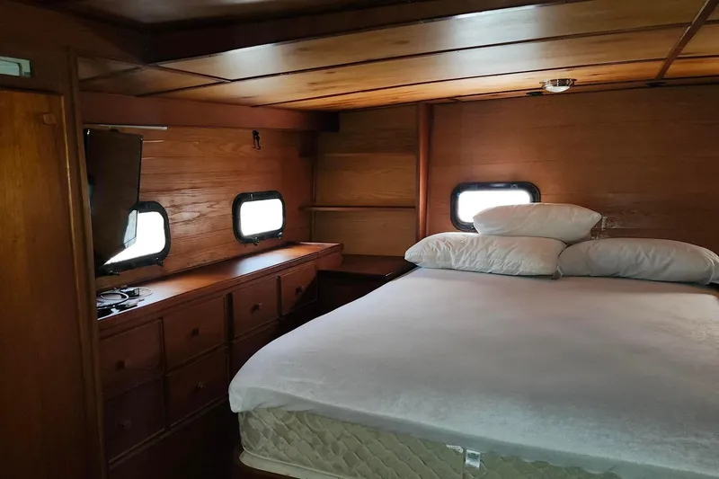 Slide: The Image of 1979 Marine Trader 50 Trawler cabin with wooden interior and cozy bed. - 25