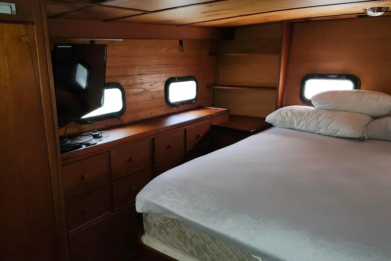 Slide: The Image of Cozy bedroom in 1979 Marine Trader 50 Trawler with wood paneling and porthole windows. - 28