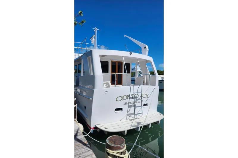 Slide: The Image of 1979 Marine Trader 50 Trawler docked, rear view with ladder and clear blue sky. - 3