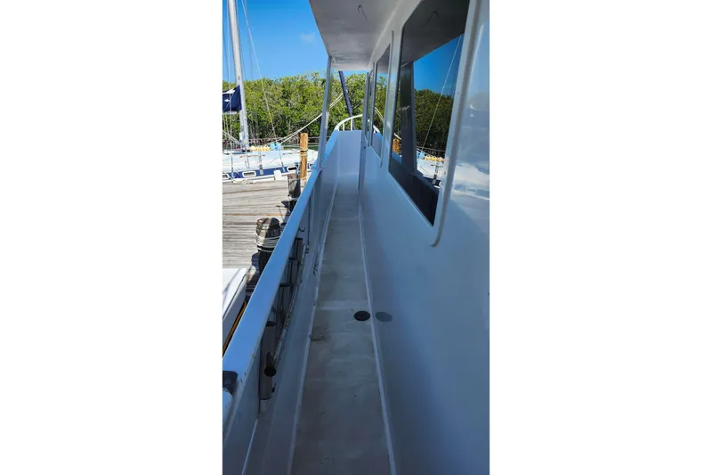 Slide: The Image of 1979 Marine Trader 50 Trawler deck view, showcasing sleek design and spacious walkway. - 4