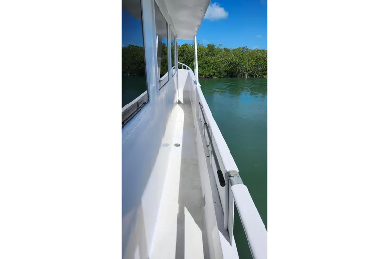Slide: The Image of Side deck of 1979 Marine Trader 50 Trawler, overlooking calm water and greenery. - 5