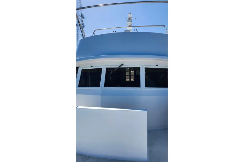 Slide: The Image of 1979 Marine Trader 50 Trawler, blue and white exterior, docked under clear sky. - 8