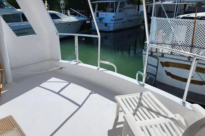 Slide: The Image of 1979 Marine Trader 50 Trawler deck with railing, docked near other boats. - 9