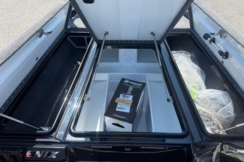 Slide: The Image of Open storage compartment of 2026 Phoenix 721 ZXL boat with Mercury box inside. - 11