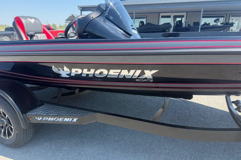Slide: The Image of 2026 Phoenix 721 ZXL boat with sleek black and red design, parked on trailer. - 4