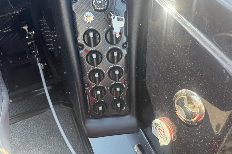 Slide: The Image of Control panel of a 2026 Phoenix 721 ZXL boat with switches and key. - 7
