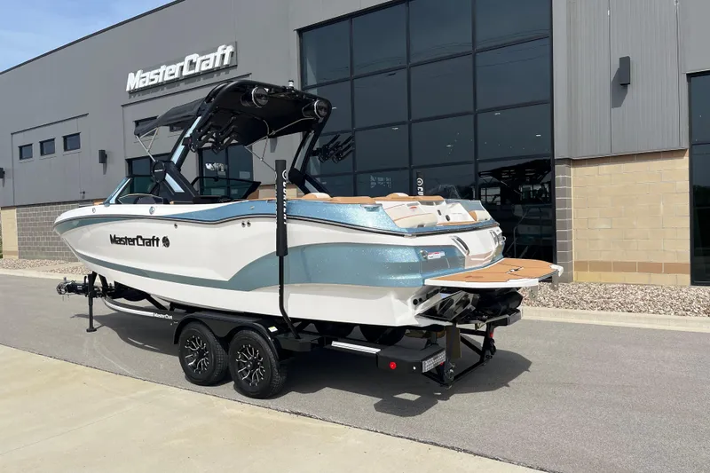 Slide: The Image of 2025 MasterCraft X24 boat on trailer outside dealership building. - 4
