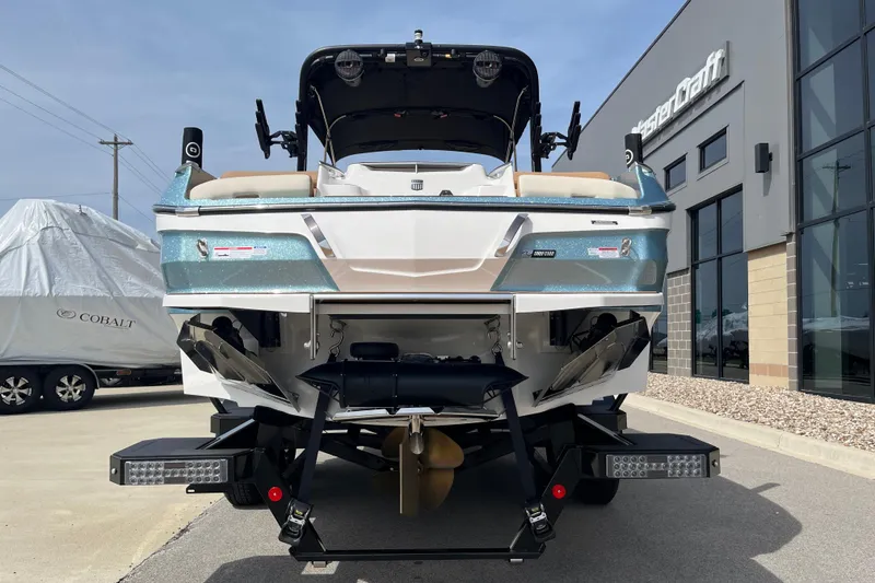Slide: The Image of 2025 MasterCraft X24 boat rear view at dealership, showcasing sleek design and features. - 5