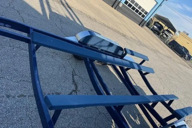 Slide: The Image of Blue boat trailer for 2024 Crownline 240 SS on asphalt near garage. - 4