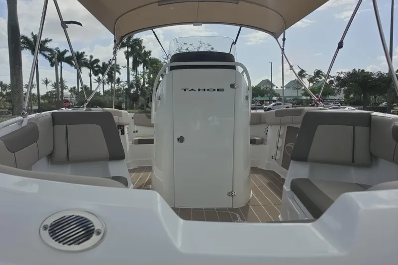 Slide: The Image of 2026 Tahoe 2150 CC boat interior with seating and canopy, parked outdoors. - 11