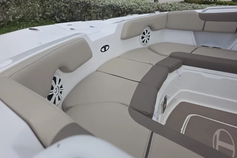 Slide: The Image of Interior seating of 2026 Tahoe 2150 CC boat with beige cushions and speakers. - 12