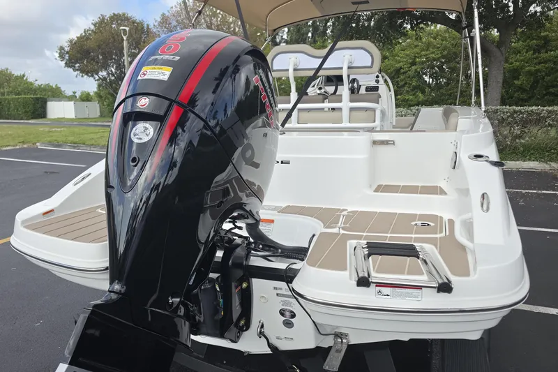 Slide: The Image of 2026 Tahoe 2150 CC boat with powerful outboard motor, parked outdoors. - 22