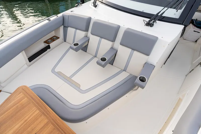 Slide: The Image of Manufacturer Provided Image: 2026 Boston Whaler 380 Realm boat seating area with gray cushions and cup holders. - 5