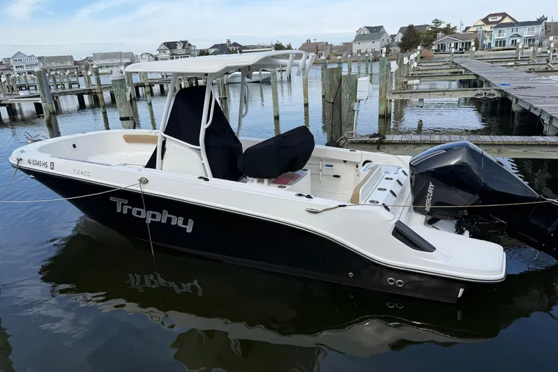The Image of 2023 Bayliner Trophy T24CC boat docked at marina with Mercury outboard engine. - 1