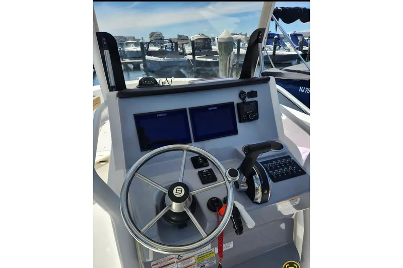 Slide: The Image of 2023 Bayliner Trophy T24CC helm with dual Simrad displays and steering wheel. - 4