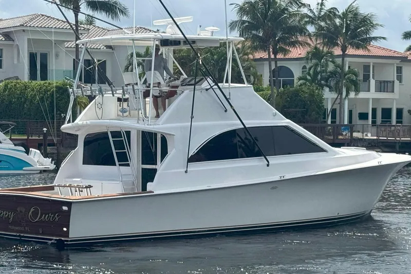 The Image of 1997 Ocean Yachts 48 Super Sport boat docked near waterfront homes. - 0