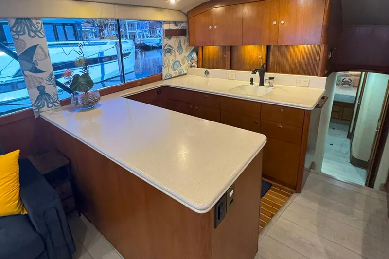 Slide: The Image of Interior of 1997 Ocean Yachts 48 Super Sport, featuring a spacious kitchen with wooden cabinetry. - 10