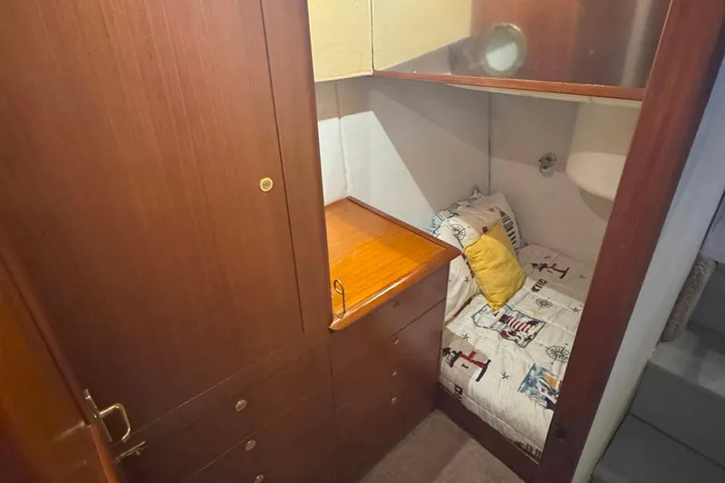 Slide: The Image of Cozy cabin interior of 1997 Ocean Yachts 48 Super Sport with wooden cabinetry and nautical bedding. - 23