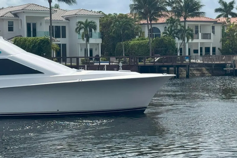 Slide: The Image of 1997 Ocean Yachts 48 Super Sport yacht near waterfront homes and palm trees. - 24