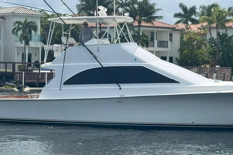 Slide: The Image of 1997 Ocean Yachts 48 Super Sport boat docked near waterfront homes. - 28