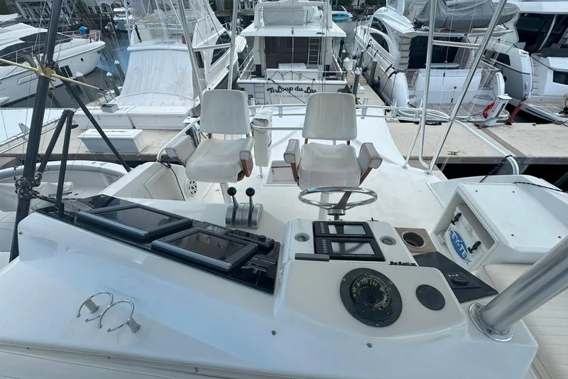 Slide: The Image of 1997 Ocean Yachts 48 Super Sport cockpit with helm, controls, and marina view. - 32