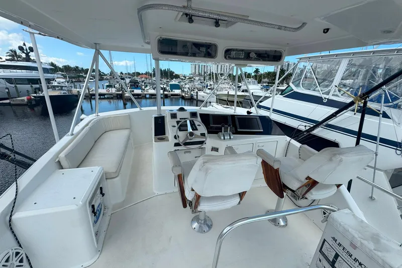 Slide: The Image of 1997 Ocean Yachts 48 Super Sport cockpit with helm, seating, and marina view. - 33