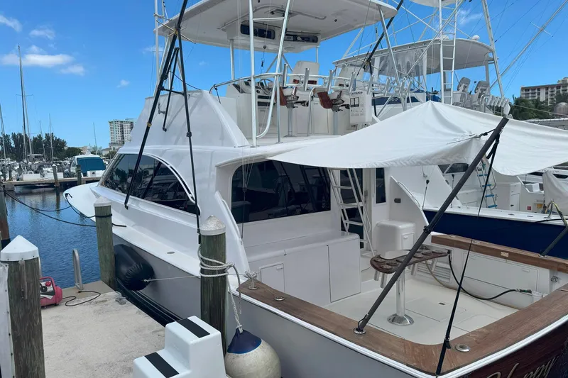 Slide: The Image of 1997 Ocean Yachts 48 Super Sport docked at marina, featuring spacious deck and canopy. - 46