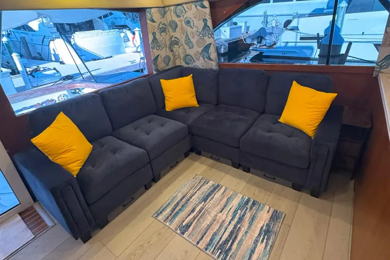 Slide: The Image of Luxurious 1997 Ocean Yachts 48 Super Sport interior with plush seating and vibrant yellow cushions. - 7